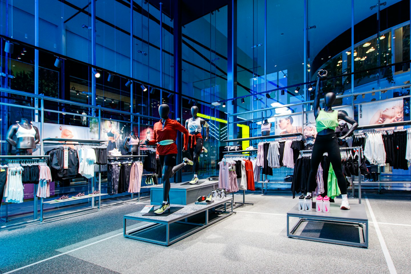 Mannequins in athletic poses display activewear in a modern store.